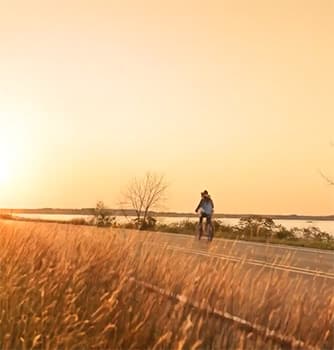 A person on an e-bike riding into the sunset