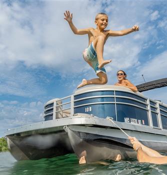 A kid jumping off a boat into the water