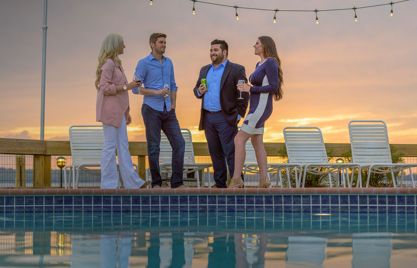 Friends Socializing by Pools Edge at Sunset