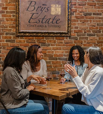 Four women celebrating together with a glass of wine. 
