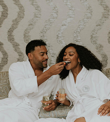 Couple celebrating Valentine's day on resort bed. 