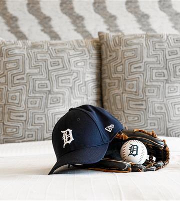 Detroit Tigers hat sitting on bed with baseball and mitt